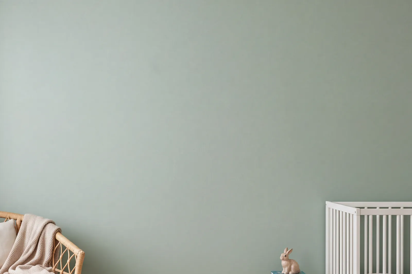 Groene kinderkamer met drie ingelijste prints boven elkaar op een rij